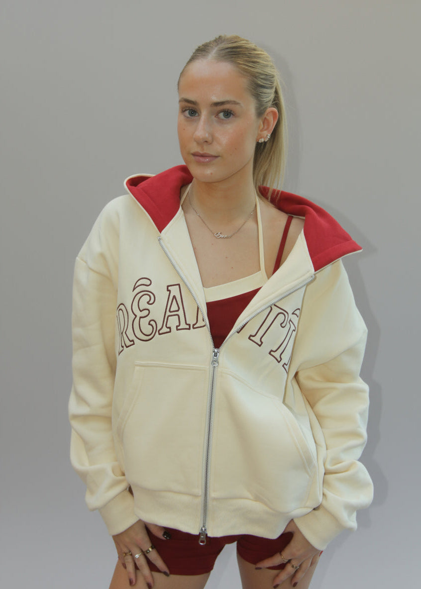 Person wearing a cream-colored hoodie with text on a white background